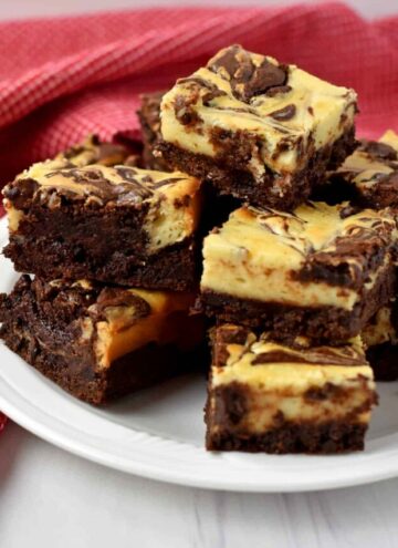 Tabletop view of a stack of gluten free cheesecake brownies.